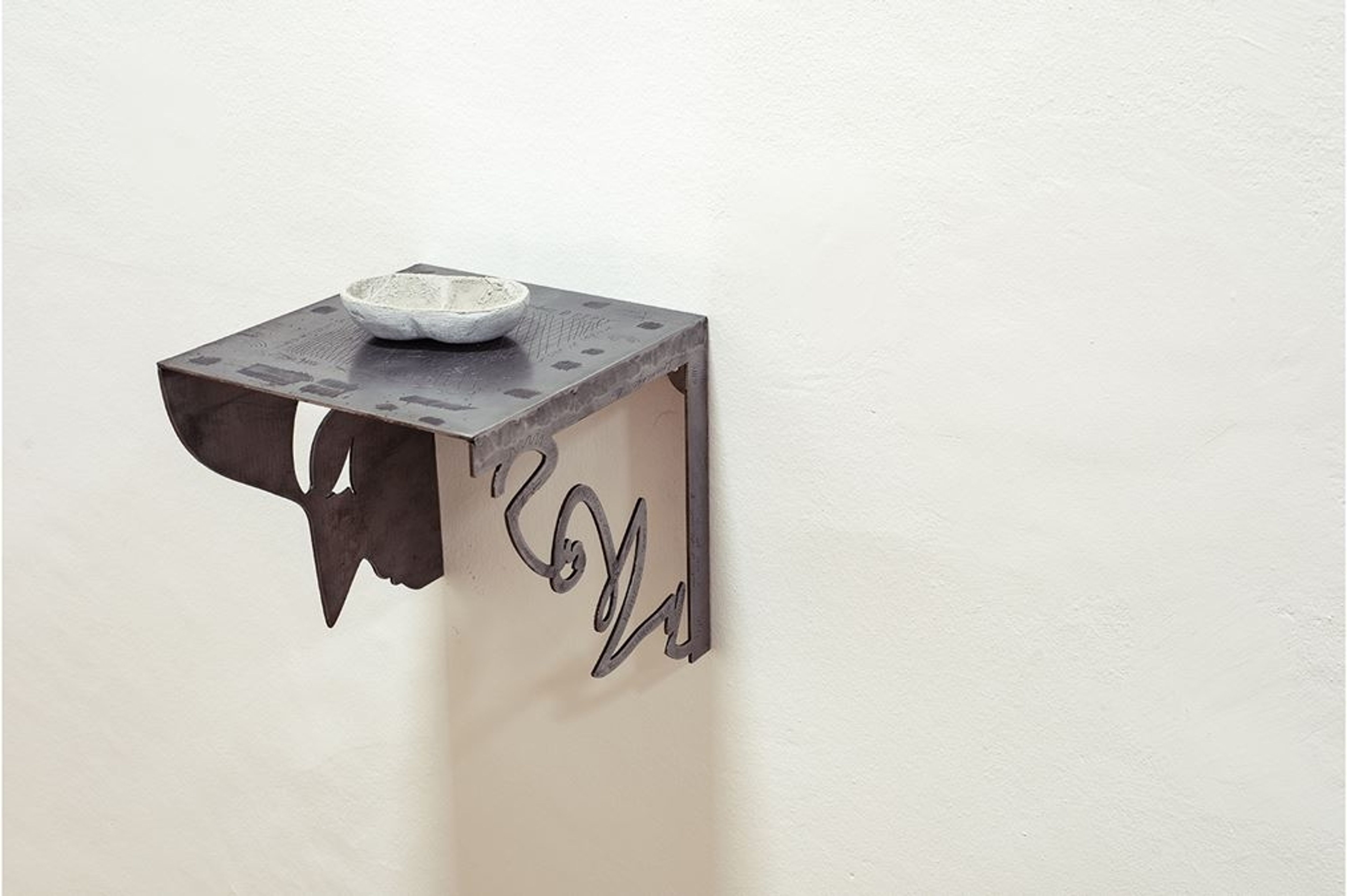 Small, rectangular shelf with a shell on a white wall.