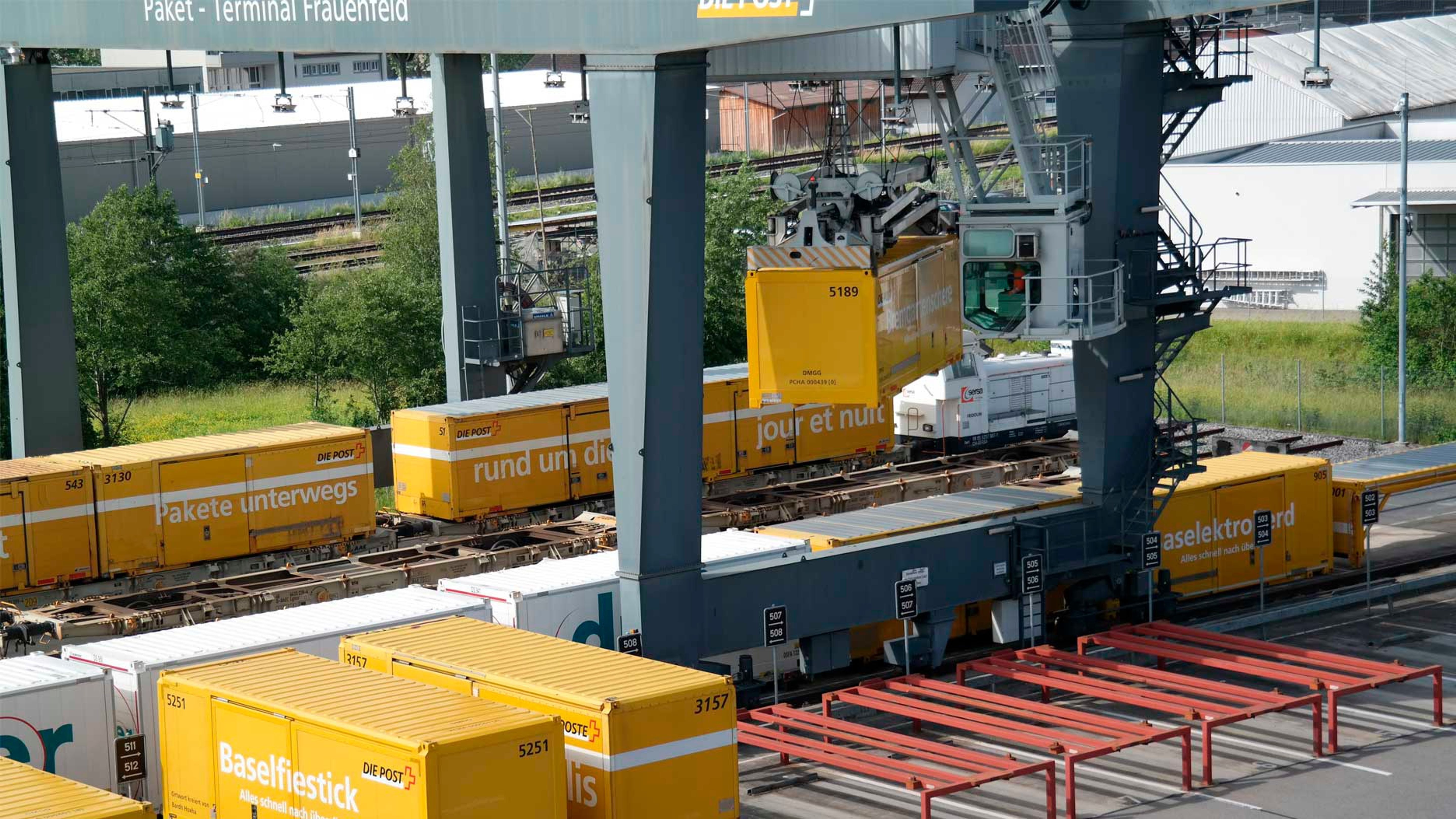 Post Transport-Container werden mit einem Hebekran auf Zugskompositionen verladen