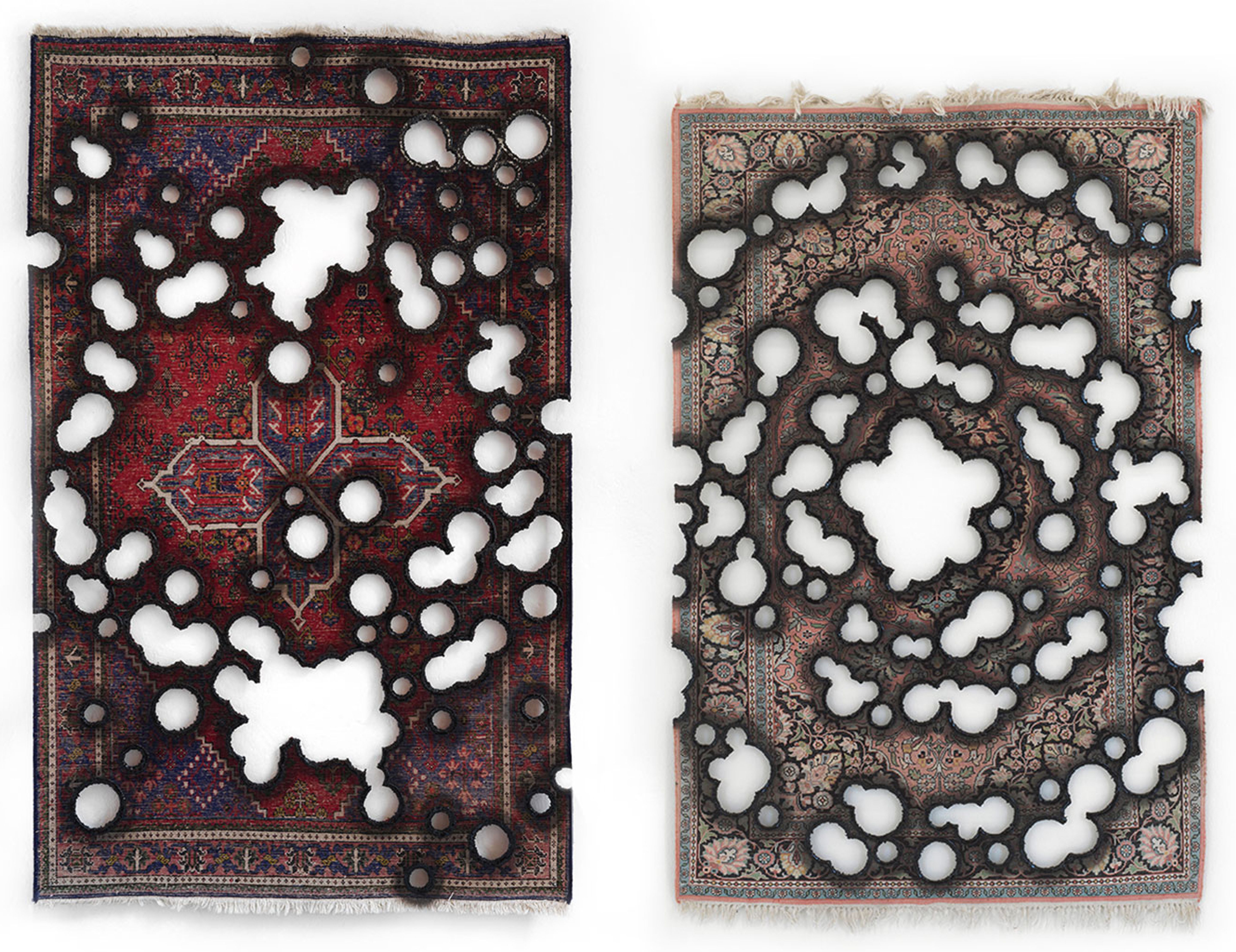 Zwei ornamental gemusterte Teppiche mit Brennlöchern vor weissem Hintergrund.