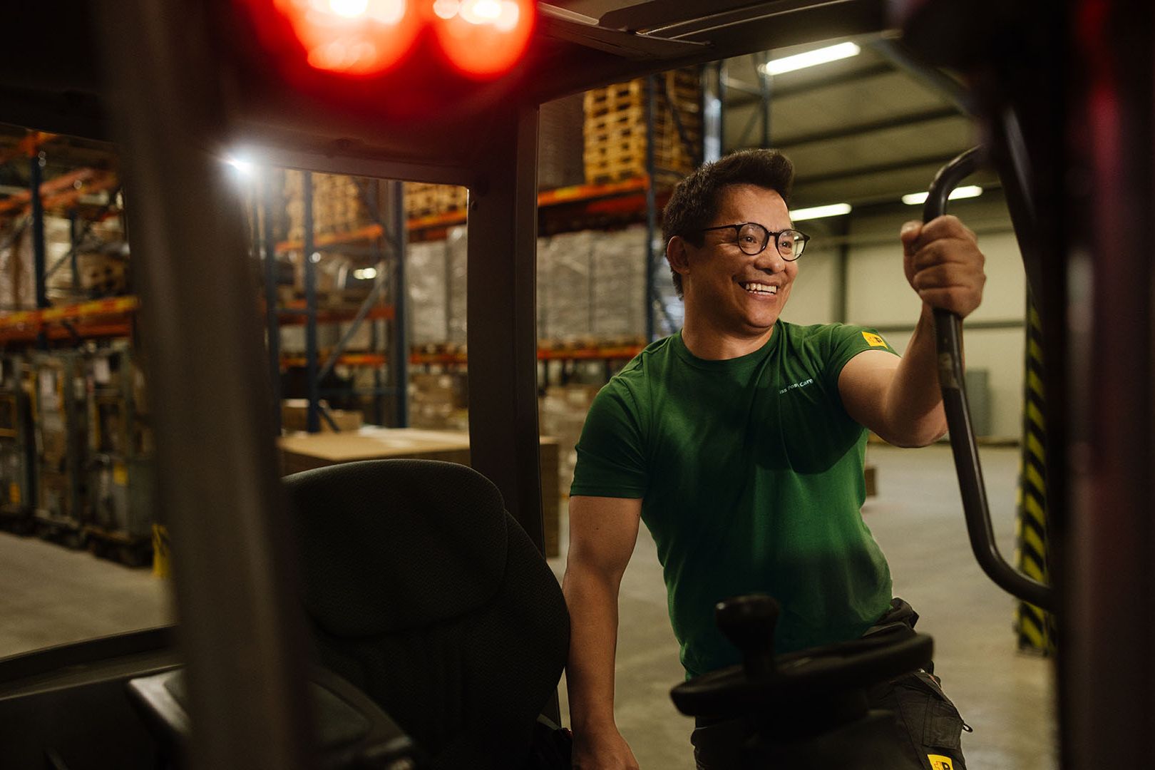 In a warehouse, a Swiss Post Cargo employee gets into the cabin of a forklift.