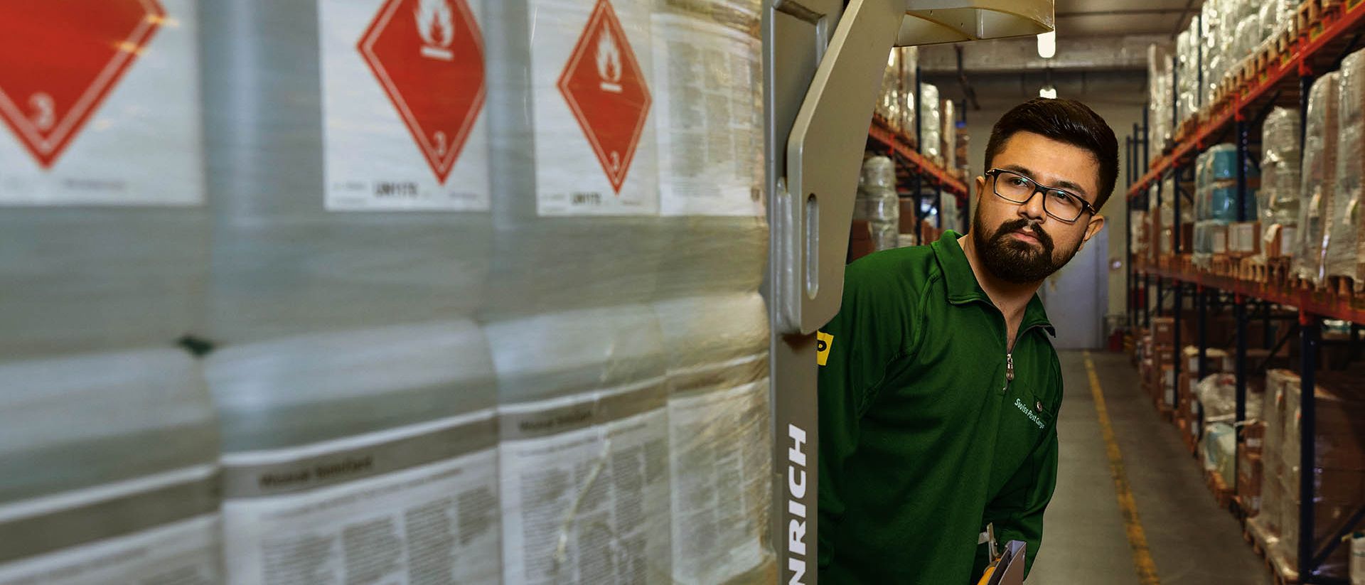 Un magazziniere trasporta merci pericolose su un transpallet nel magazzino delle sostanze pericolose.