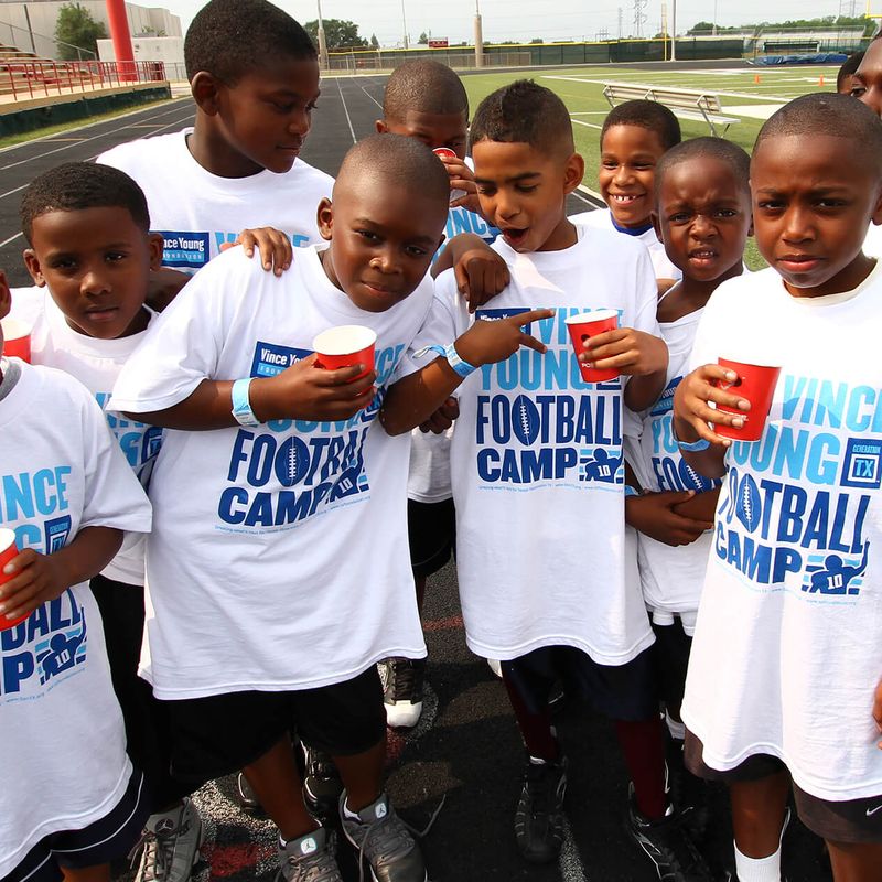 Group of young boys posing in t-shirts at football camp.