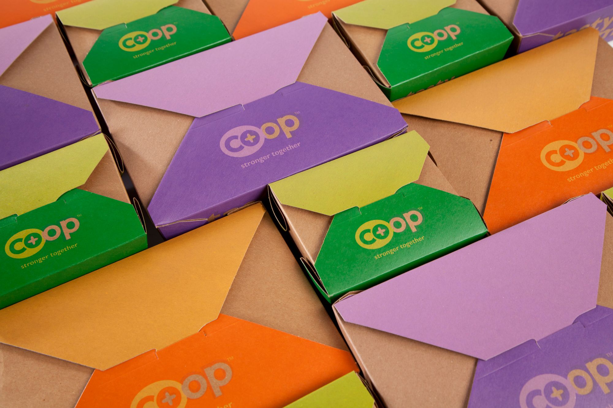 Kraft boxes with colored flap lids and the Co+op logo
