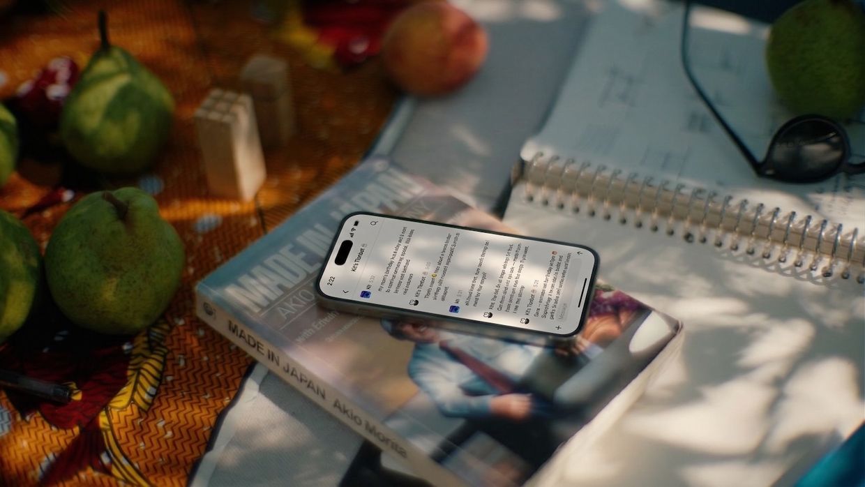 Tlon Messenger open on a phone resting on a book