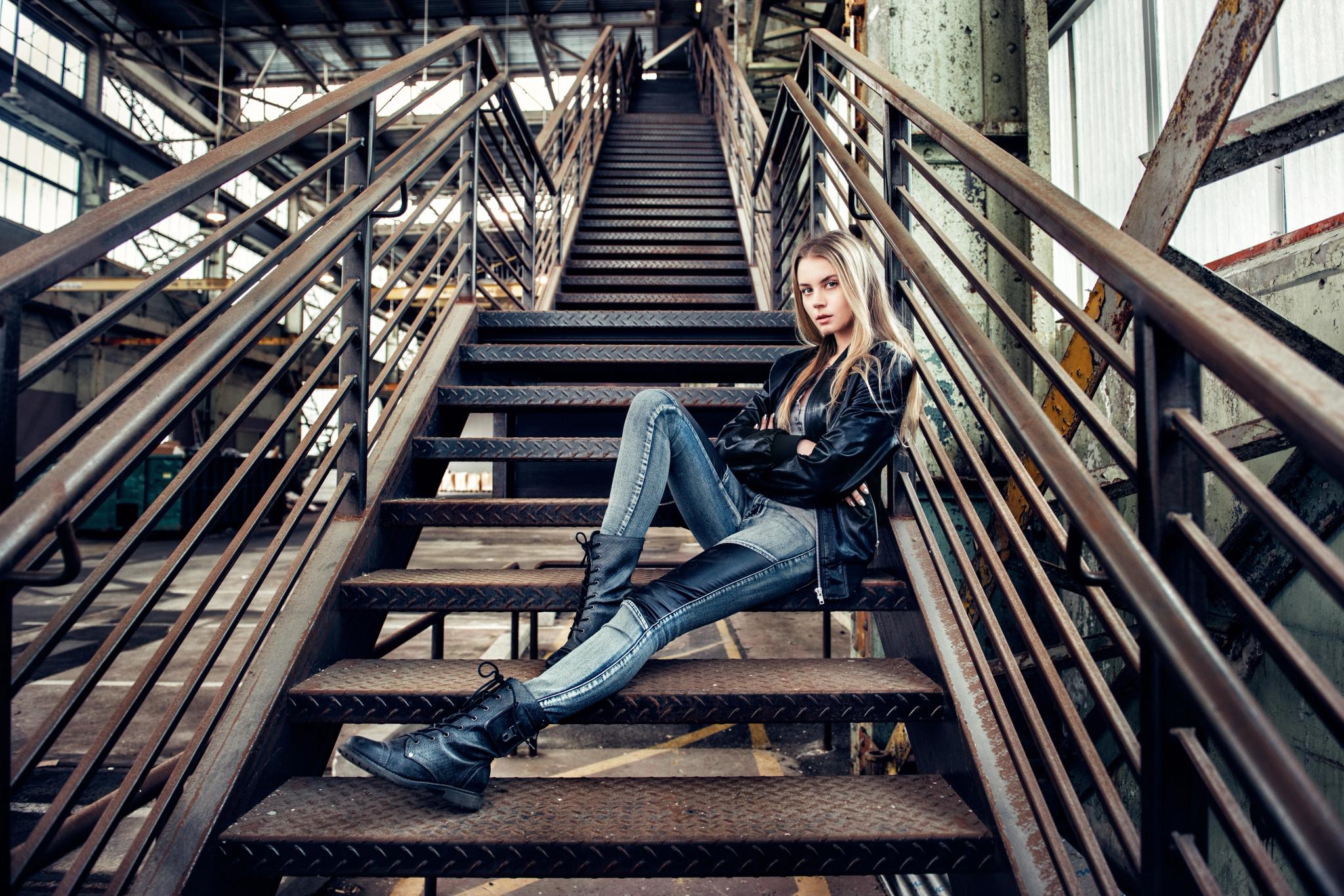 Woman with leather boots and jacket on industrial stairs