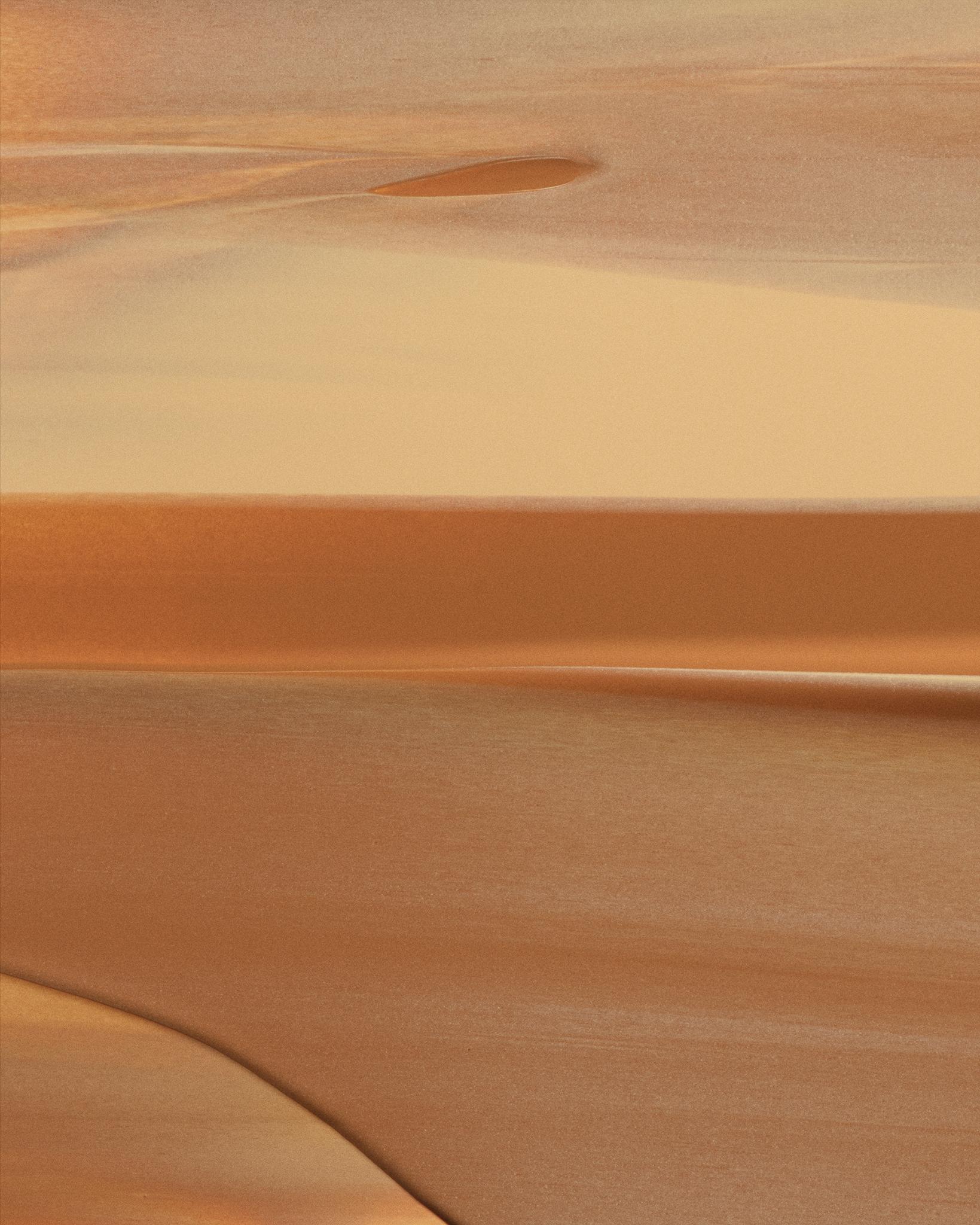Close-up texture of a smooth, creamy product smeared in layered strokes of golden amber and caramel.