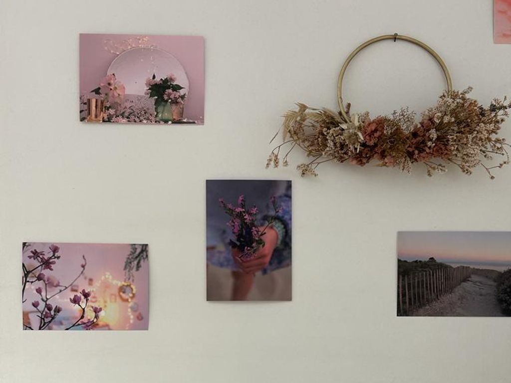 Un coin du cabinet : cartes, couronne de fleurs séchées, plante et bougies