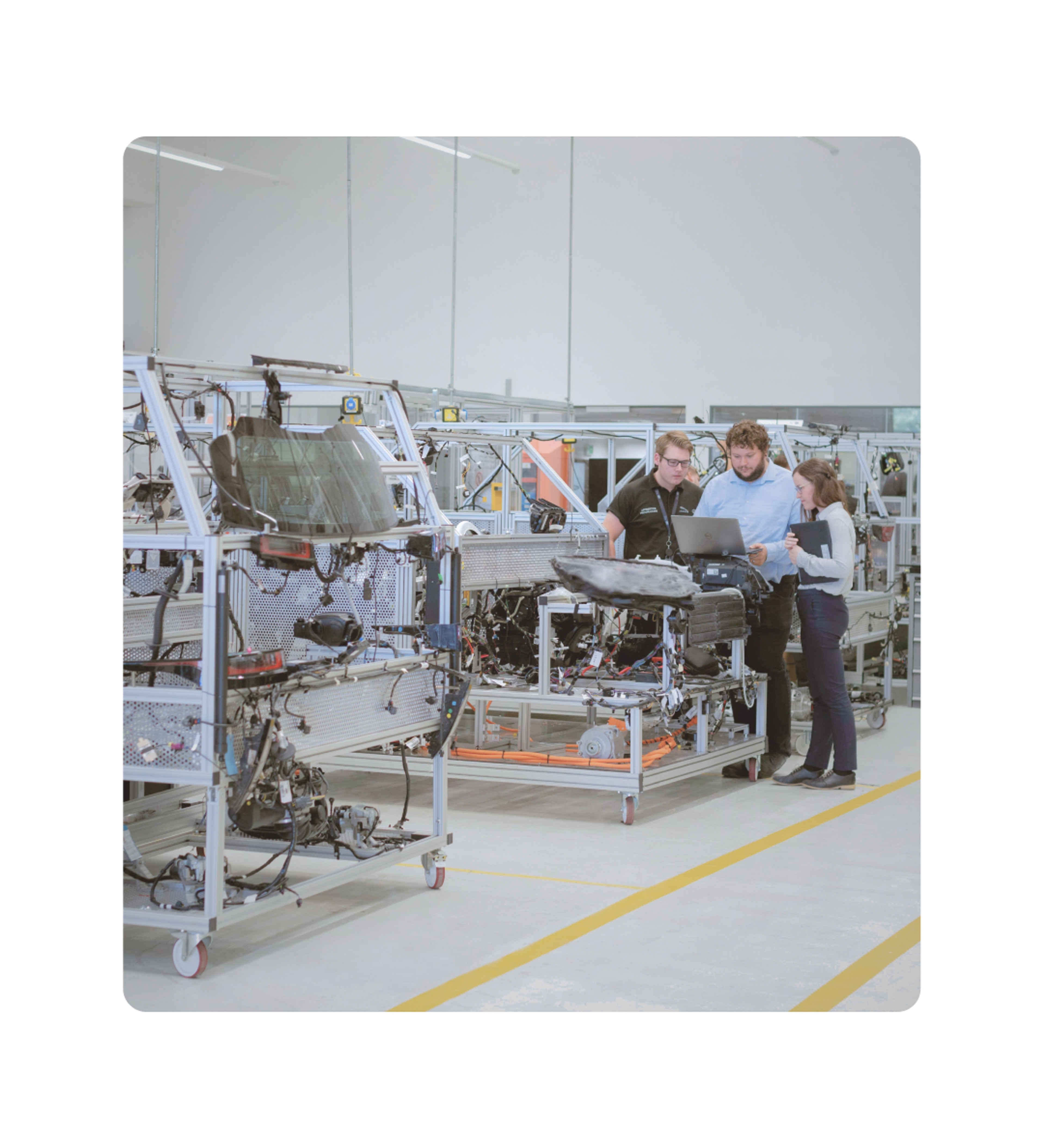 Engineers reviewing data on a laptop at an industrial manufacturing facility