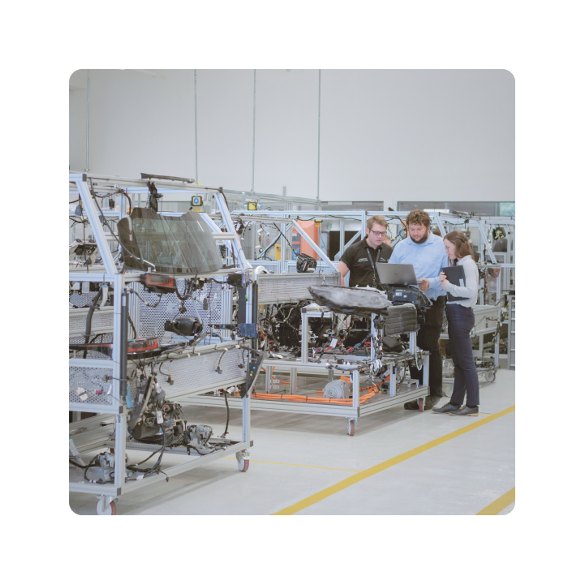 Engineers reviewing data on a laptop at an industrial manufacturing facility
