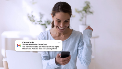 Woman smiling at phone screen and excited because she received a digital Mastercard as a gift