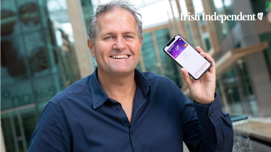 Kealan Lennon, founder and CEO of CleverCards, holding a phone showing a CleverCard