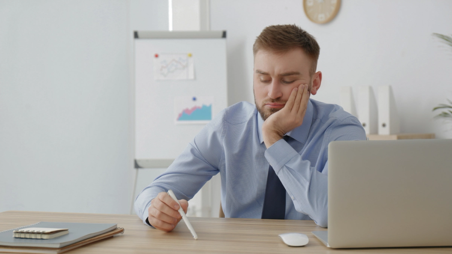 Bored employee holding a pen in his hand