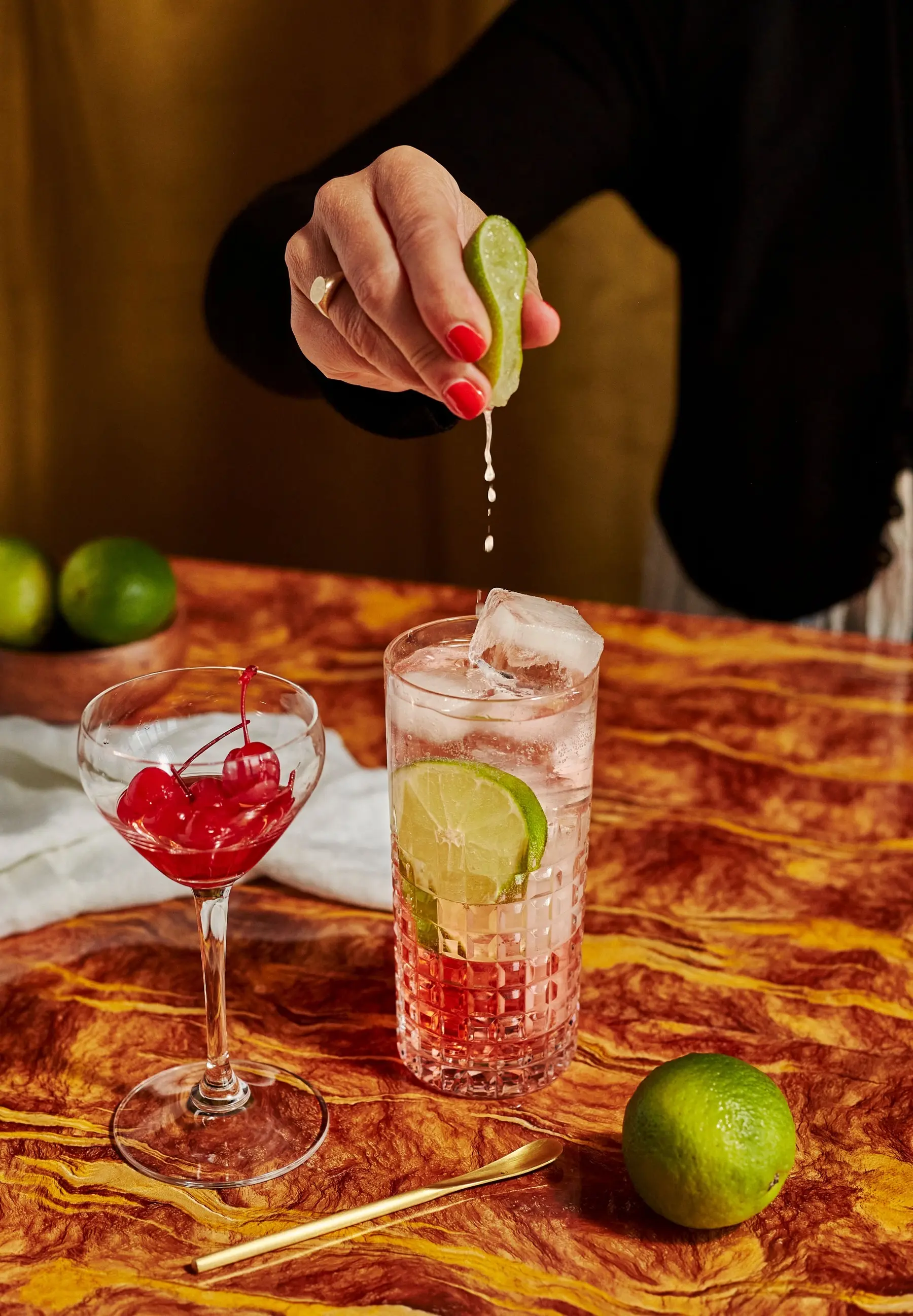hand squeezing lime into mocktail