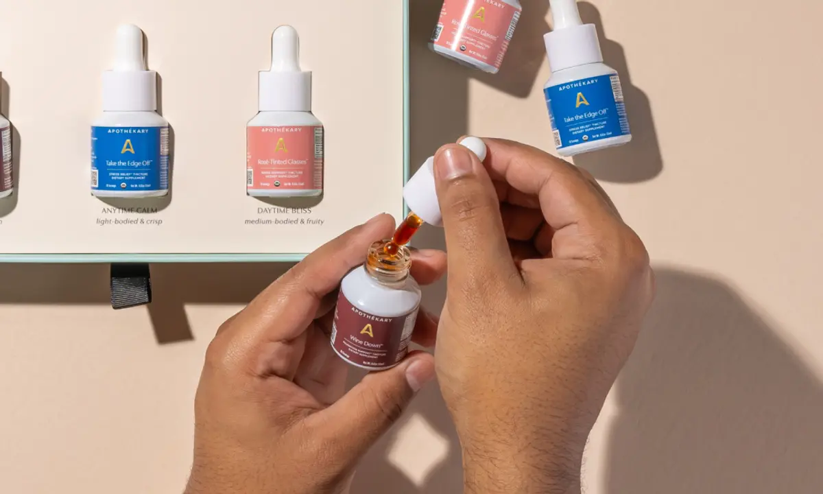 Photograph of a hand holding Wine Down tincture