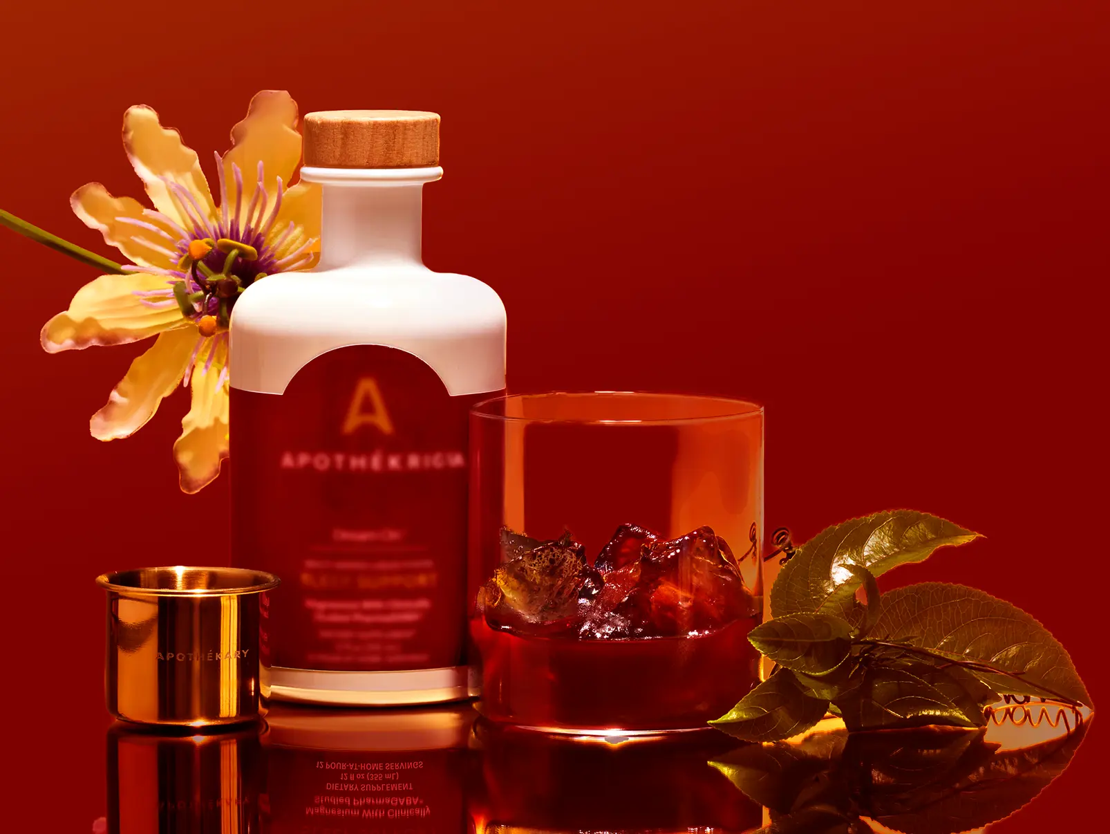 Apothékary product bottle with a glass with ice, passionflower, and green leaves against a red background.