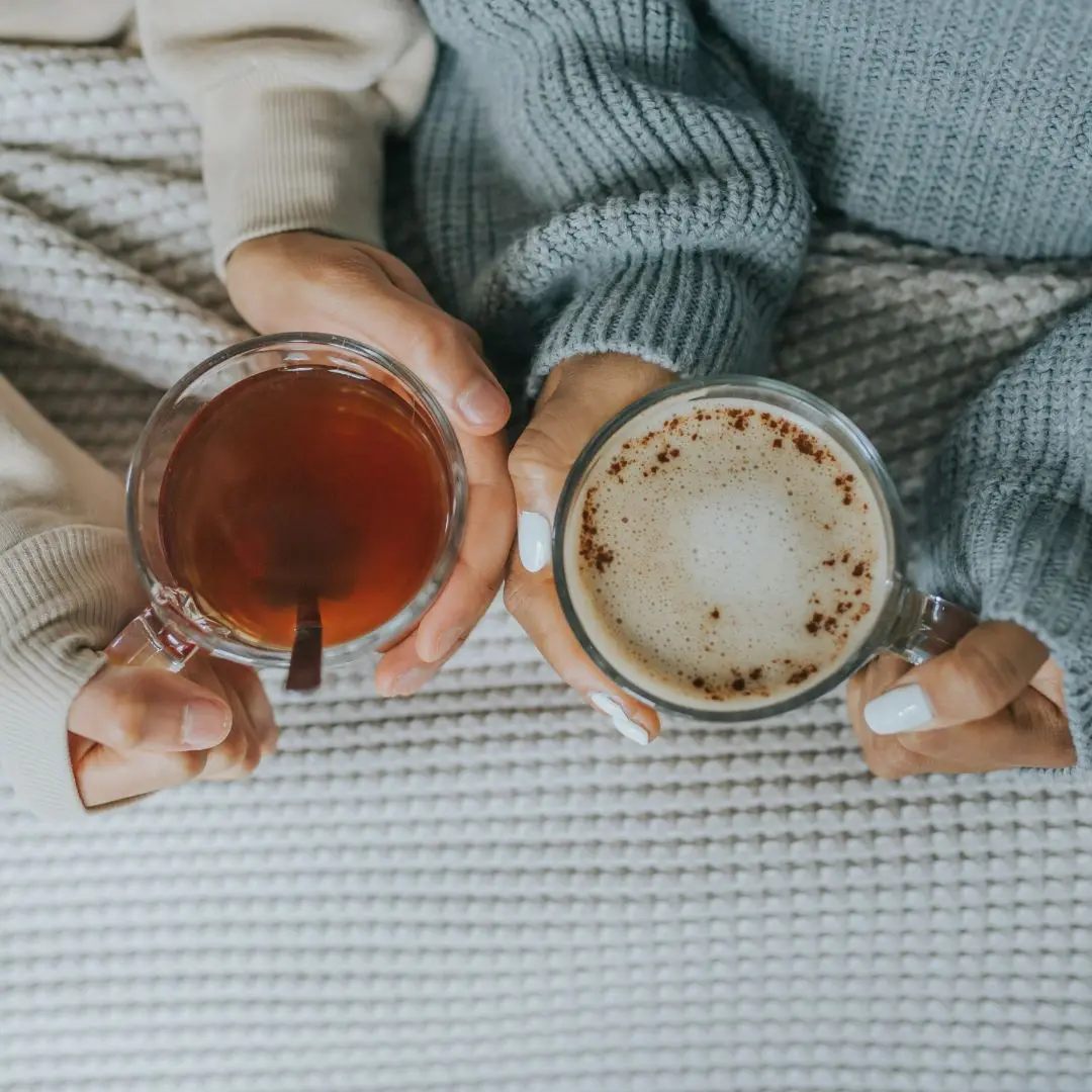 two people holding cozy fall drinks