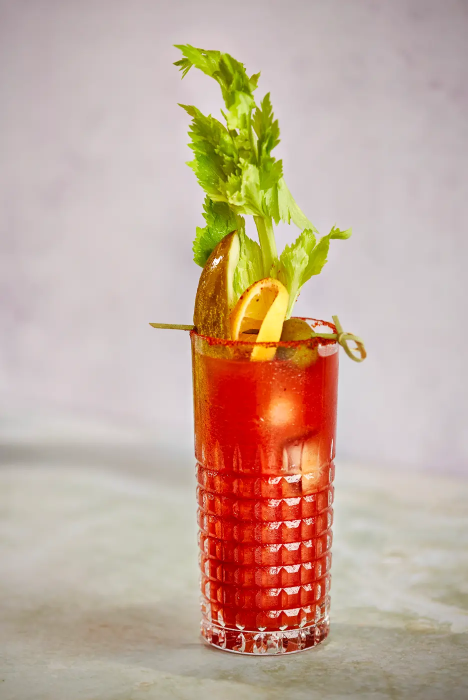 bloody mary in a clear glass with celery and pickles