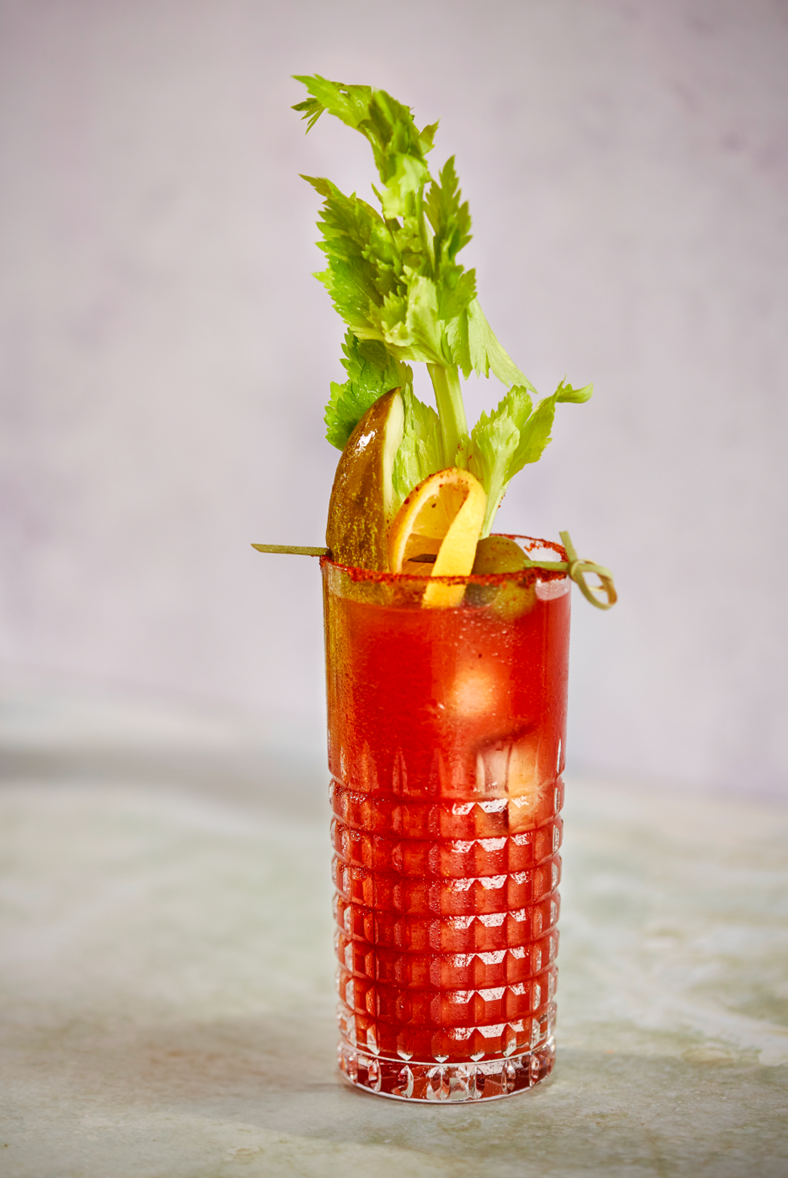 bloody mary in a clear glass with celery and pickles