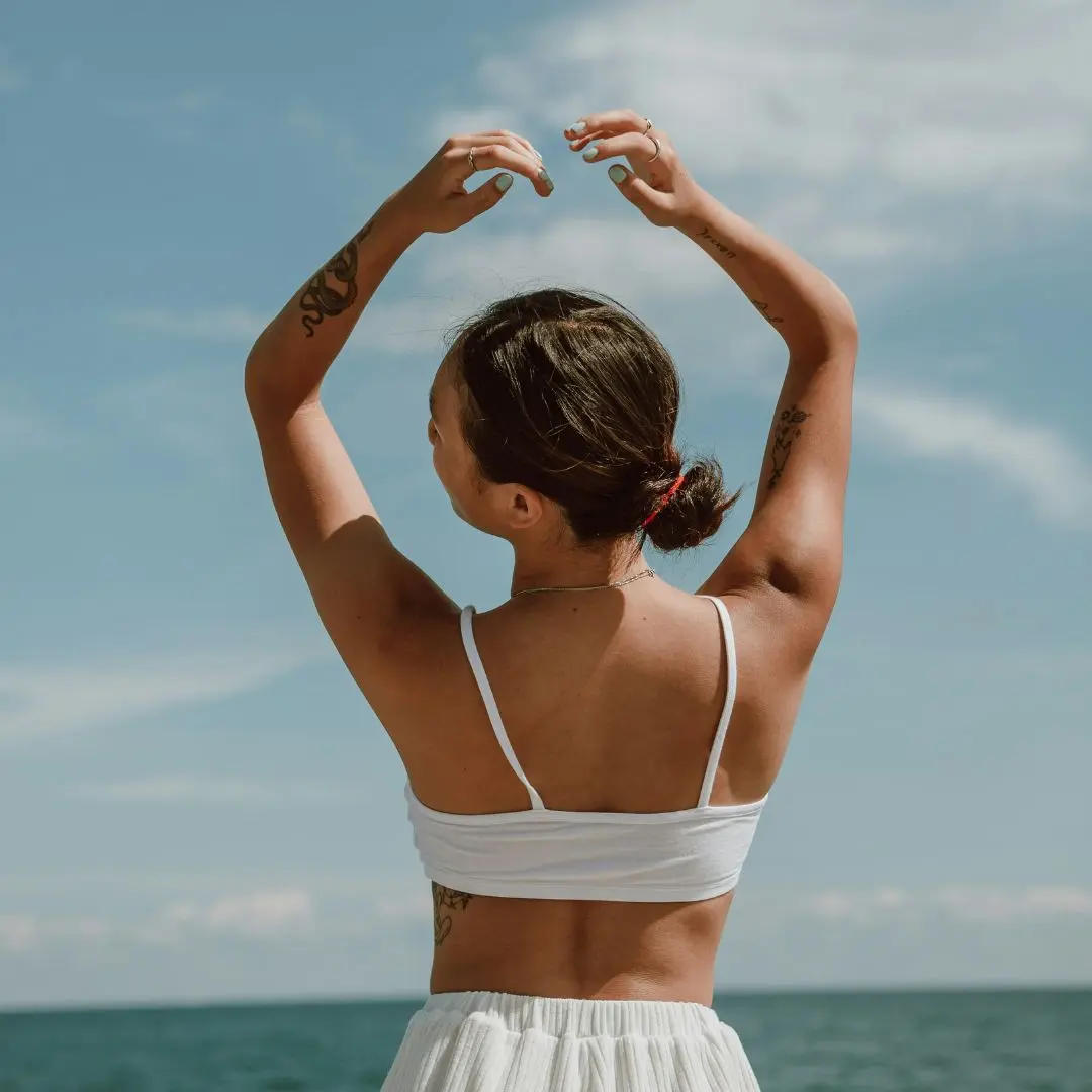 woman outside with arms up