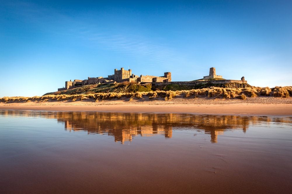 The spectacular Bamburgh Castle on Bamburgh Beach, one of the UK's best beaches in Northumberland