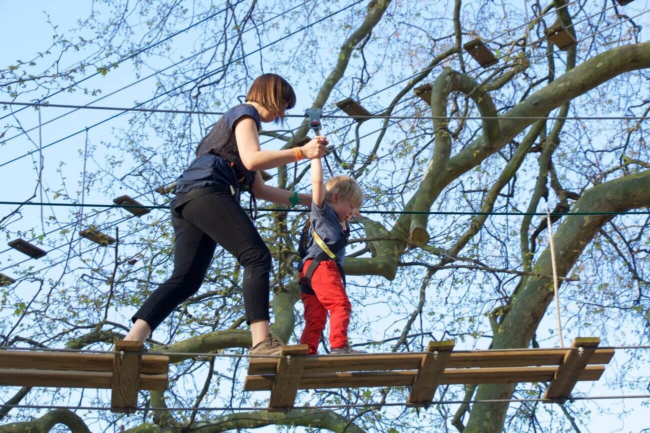 Mum and child tackling an aerial adventure course