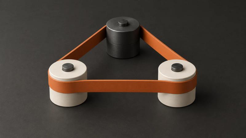 A continuous burnt-orange belt connects three ivory and charcoal rollers in a triangular mechanism.