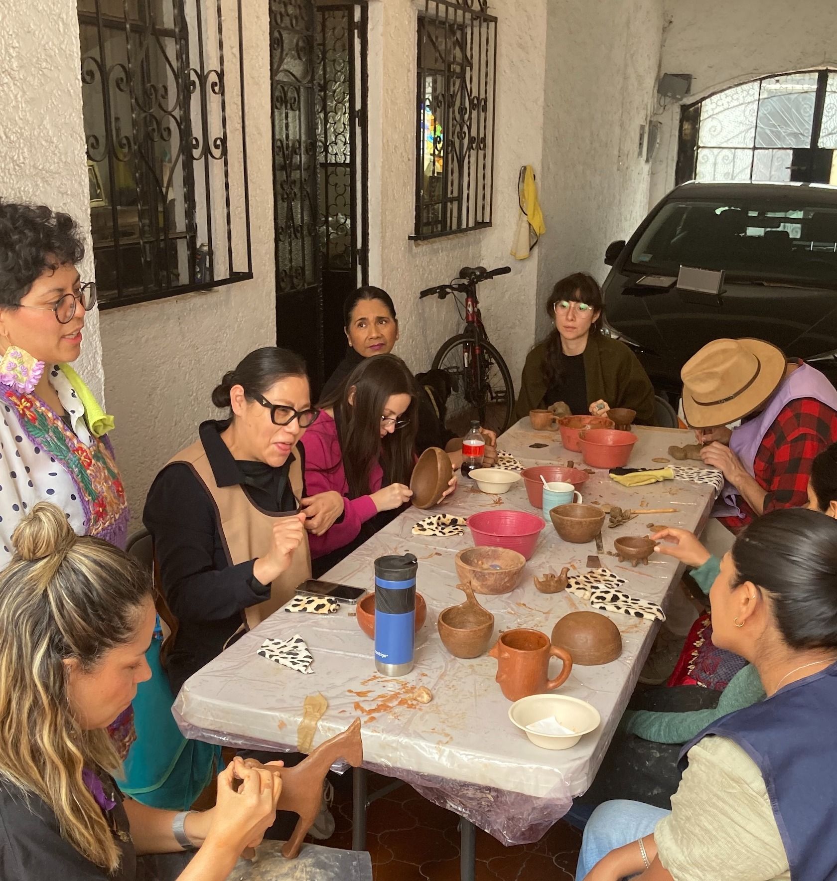 grupo de gente pintando barro rojo 