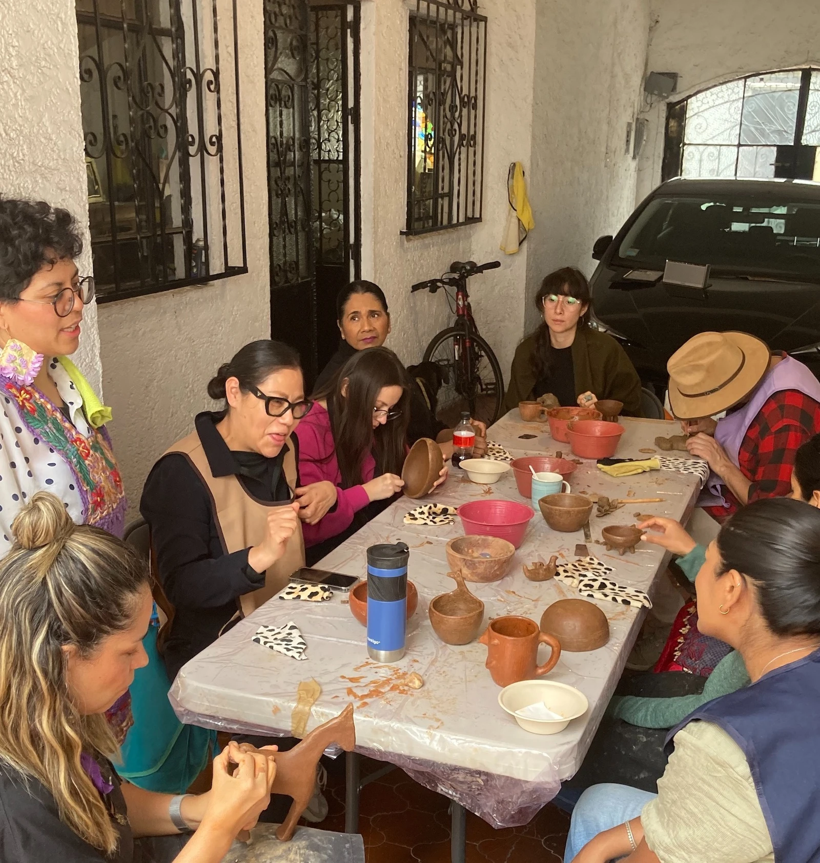 grupo de gente pintando barro rojo 