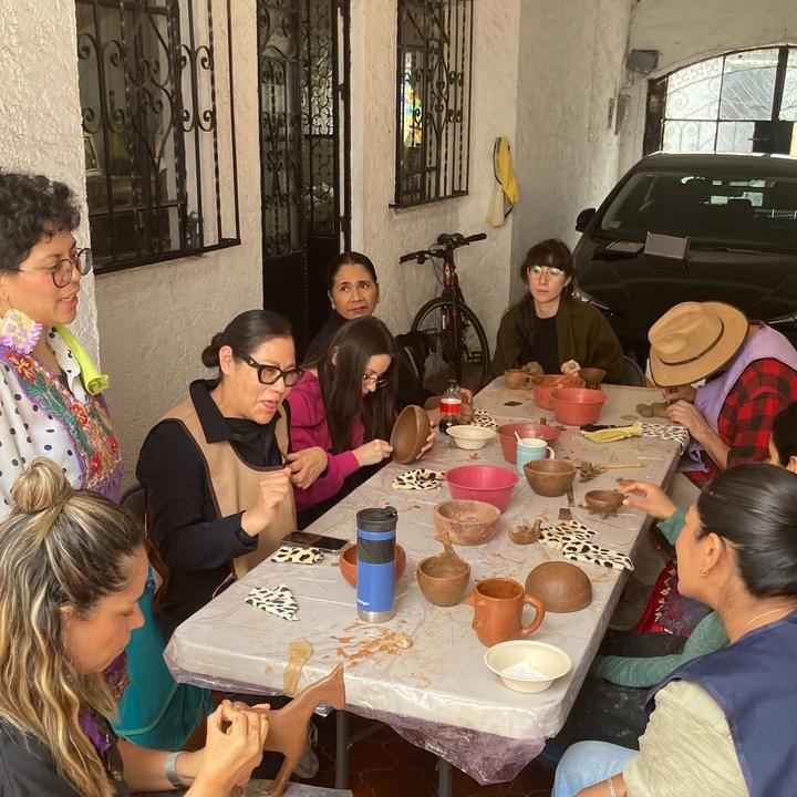 grupo de gente pintando barro rojo