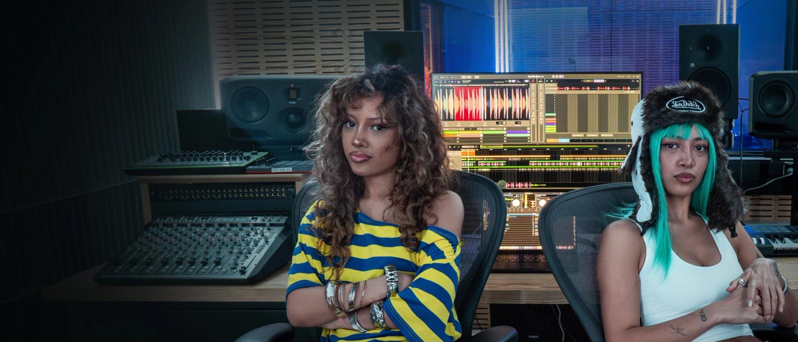 The Katayanagi Twins, DJ duo, seated in a recording studio using Serato DJ Pro and Serato Studio software.