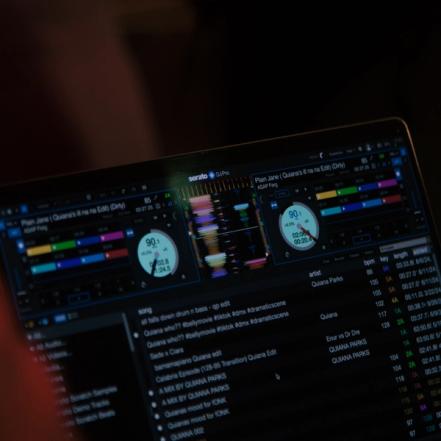 Serato DJ Pro GUI showing a two-deck layout and music library in professional DJ software.