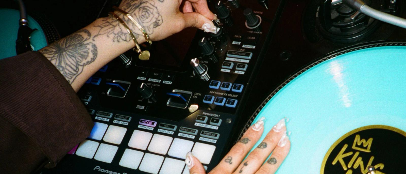 DJ King Marie’s hands on a DJ controller, performing live with Serato professional DJ software.