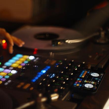 Serato DJ for iOS, a DJ app running alongside a DJ setup with a turntable and mixer.