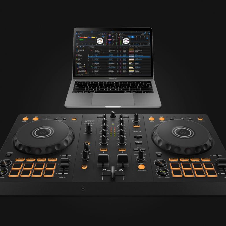 Pioneer DJ DDJ-FLX4 controller positioned in front of an open MacBook Pro displaying the Serato DJ Pro software interface with two decks and a track library.