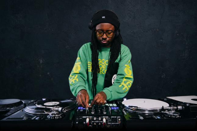 DJ OP! performing with Serato DJ Pro on turntables and a mixer.