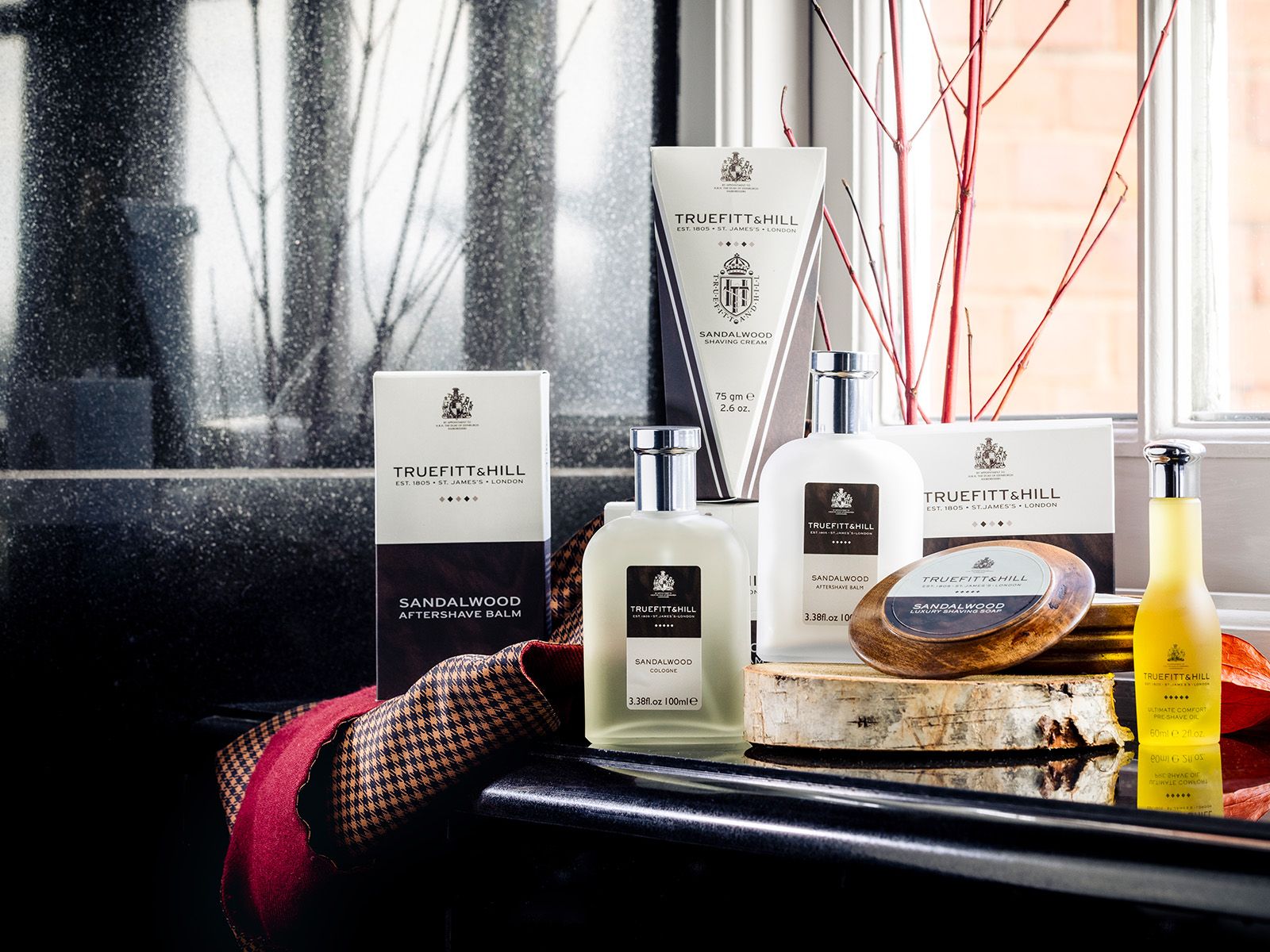 Truefitt & Hill Mayfair Cologne -pullo kultaisella korkilla vaaleanvihreän auton lokasuojalla.