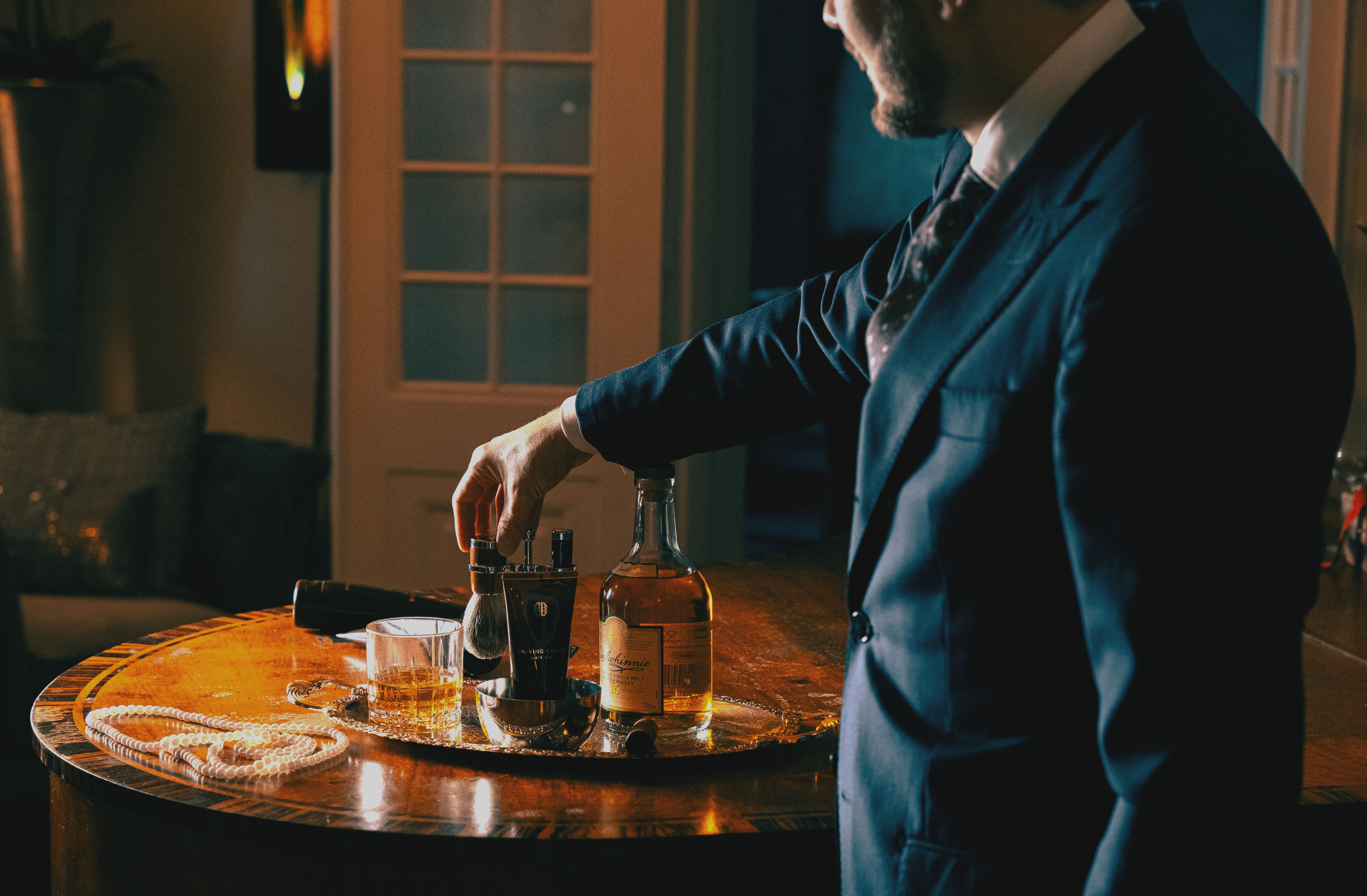 En man som håller en parfym vid ett dukat bord med granris