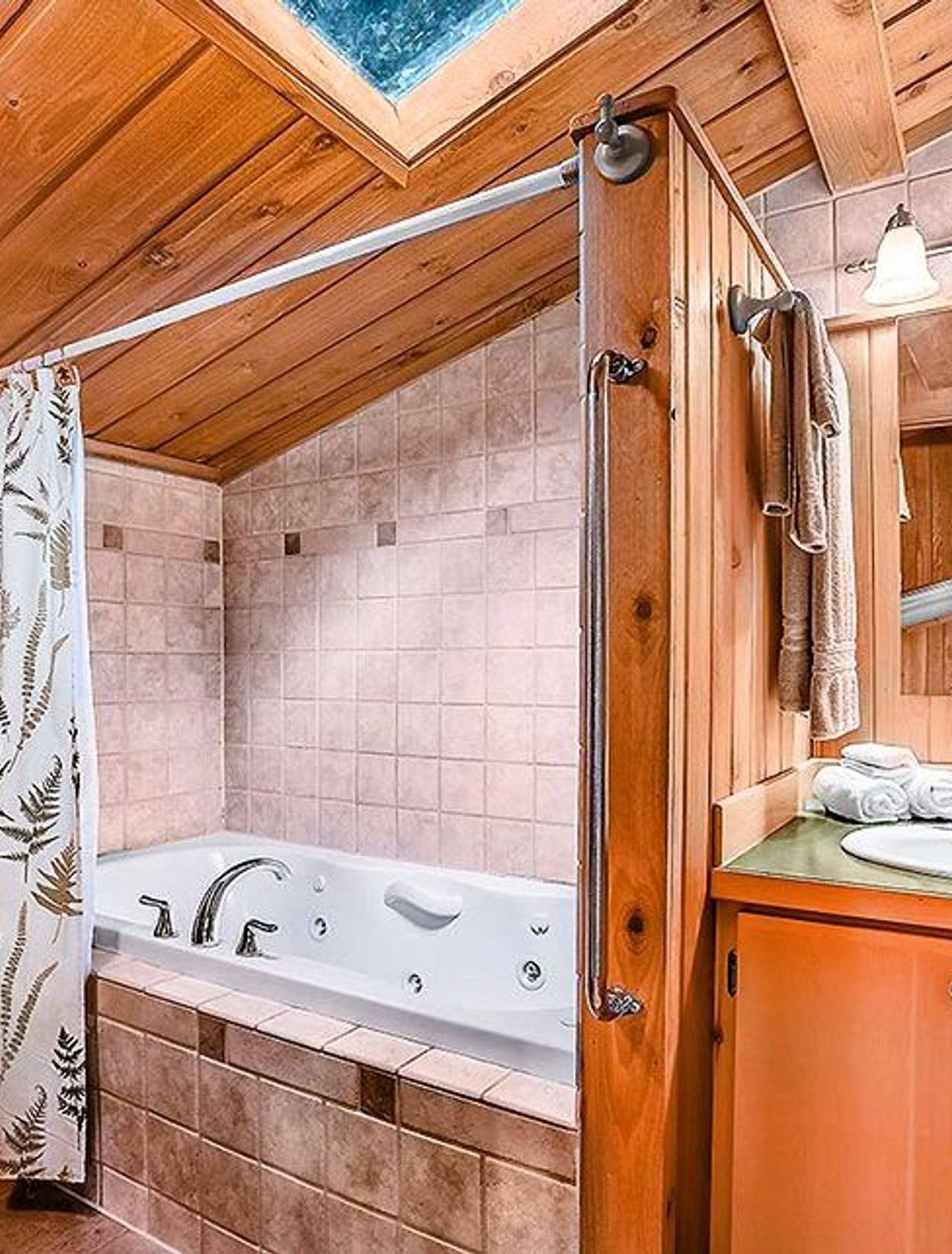 Photo of Deep Forest Cabins - Maplewild Cabin, Indoor two‑person jetted tub with skylight view