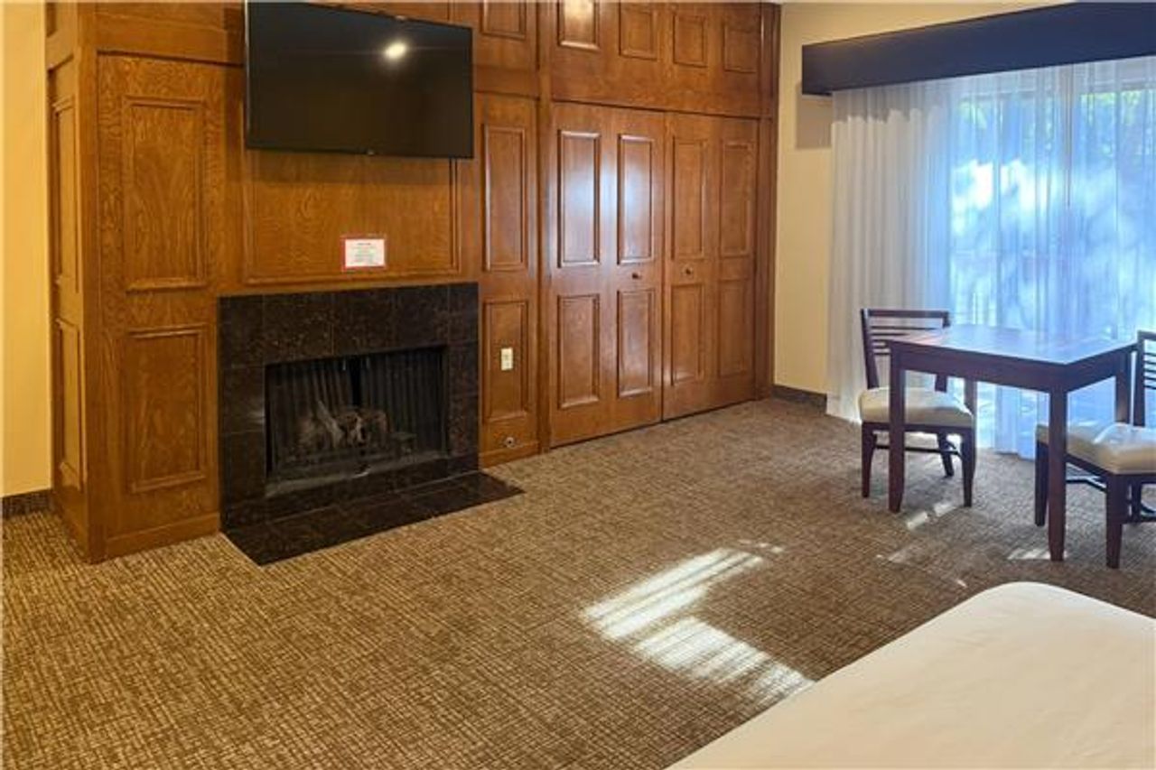 Photo of Comfort Inn Monterey Peninsula Airport - Suite, King Bed, Fireplace, Table & Chairs