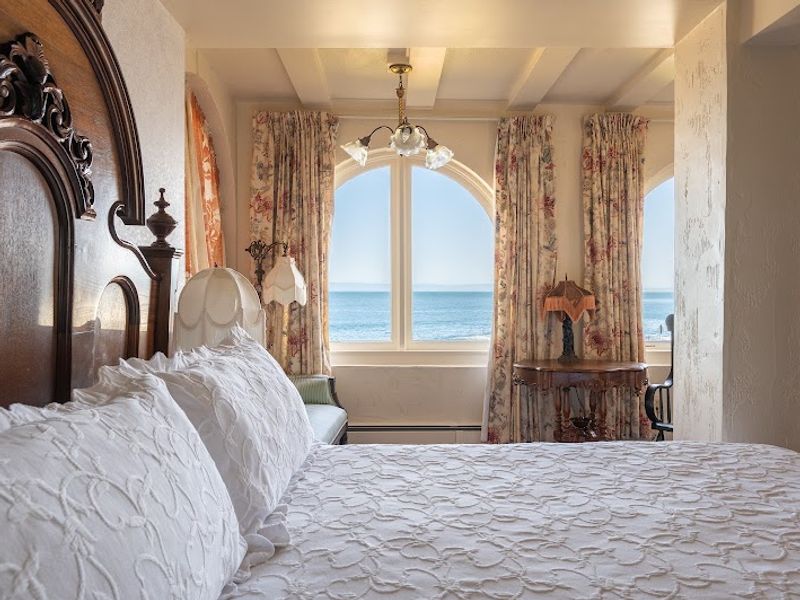 Photo of Martine Inn - Victoriana Room with king bed and arched bay windows with wonderful views of the coastline