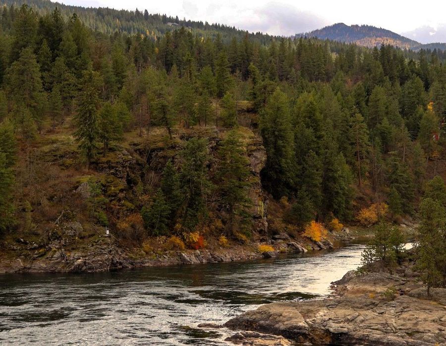 Spokane River, with a little red home on a hillside in Corbin Park near Post Falls, Idaho, USA