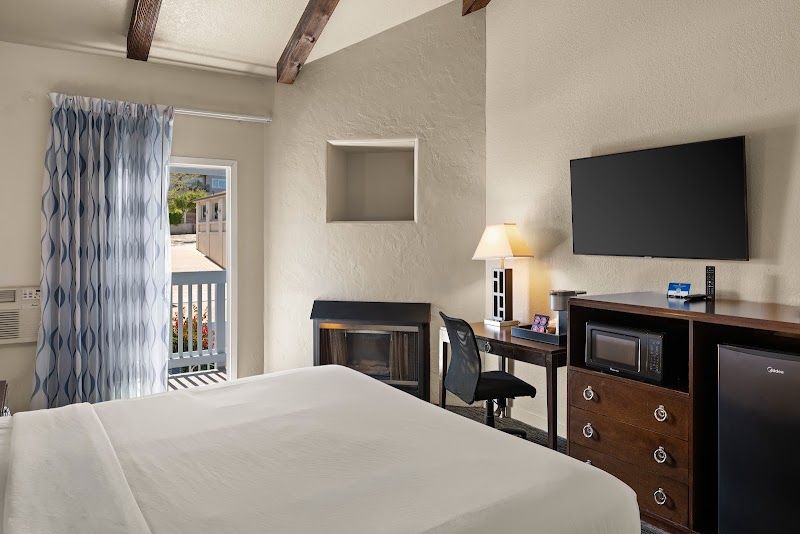 Photo of Cannery Row Inn - 1 King Room, a fireplace, microwave and refrigerator, coffee maker, and bathroom