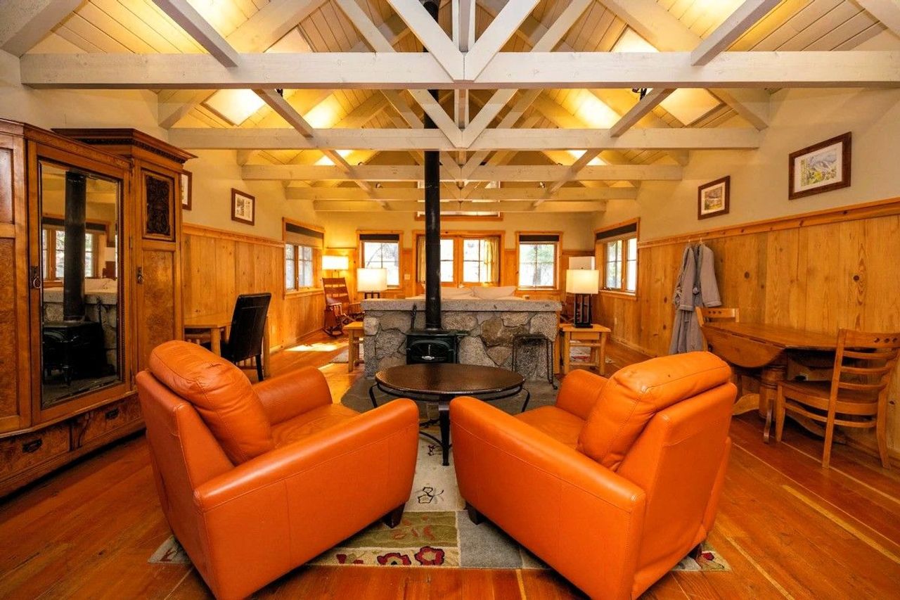 Photo of Sleeping Lady Mountain Resort & Spa - Eyrie Cabin, living room area with a wood stove with leather seating
