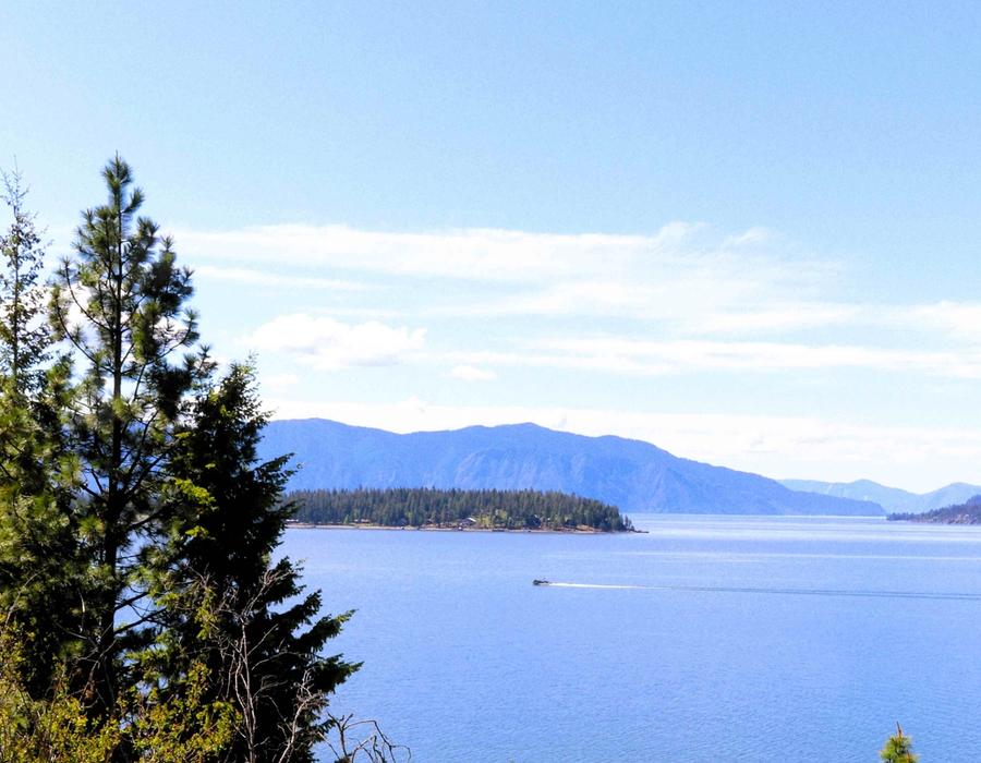 A small boat speeding by on Lake Pend Oreille, Idaho, USA