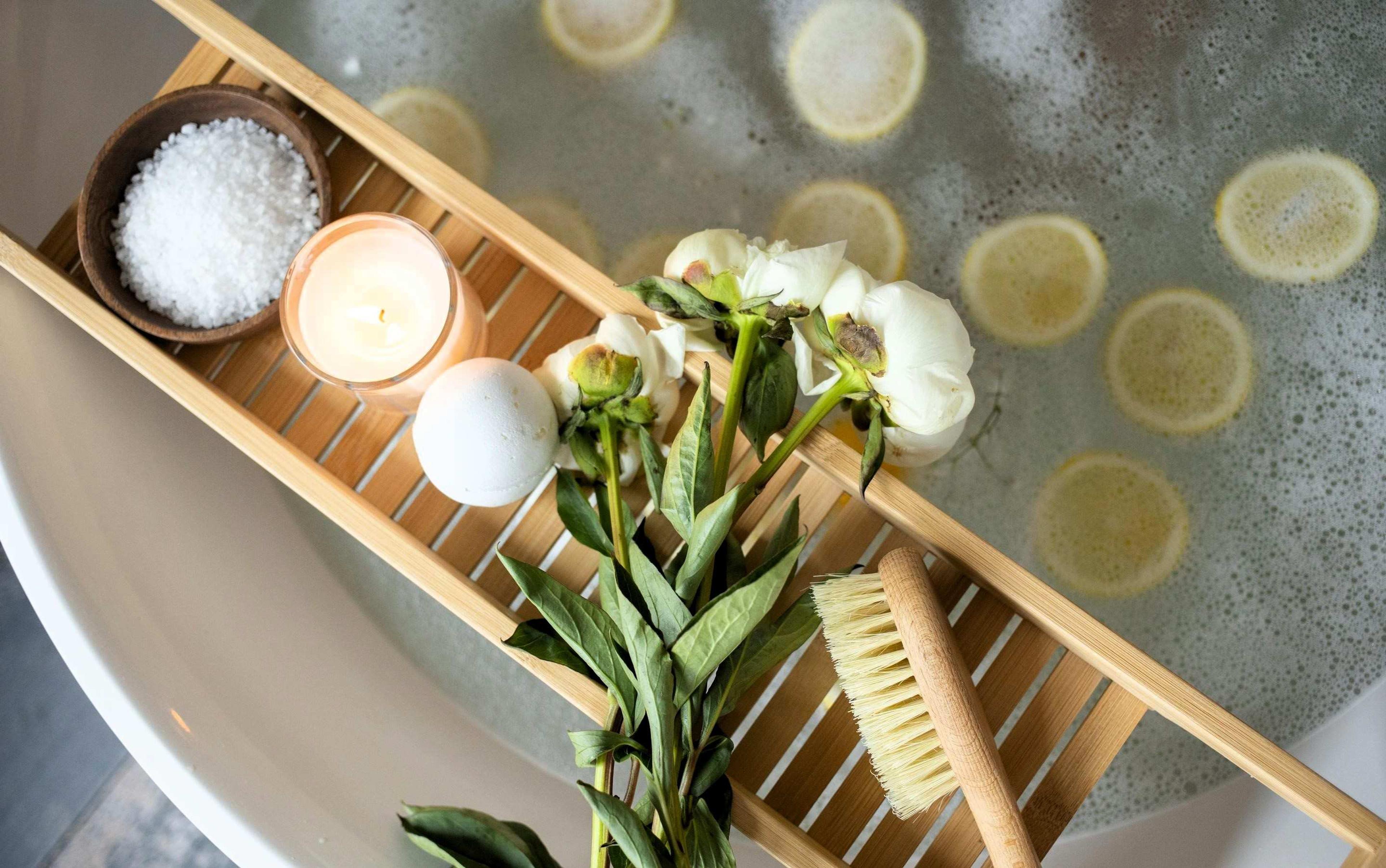 Tray with candles, flowers, and bath salts on a hot tub