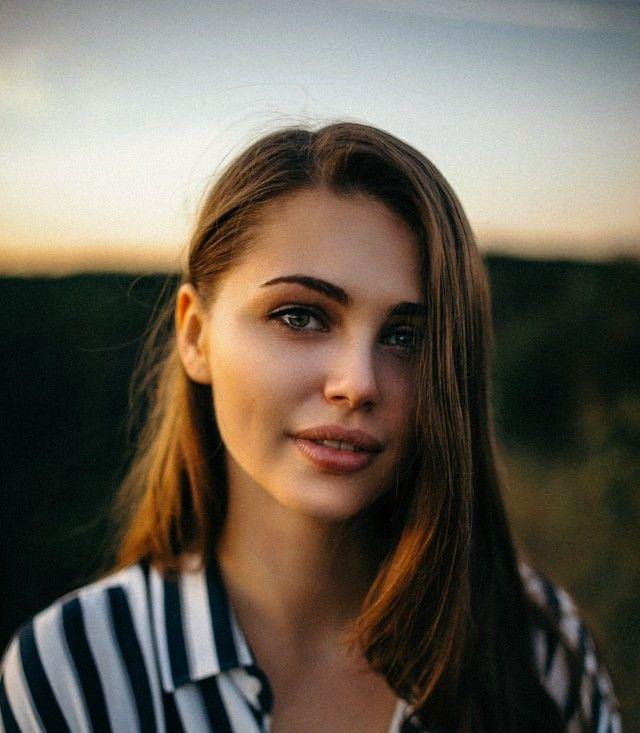 smiling woman wearing white and black pinstriped collared top