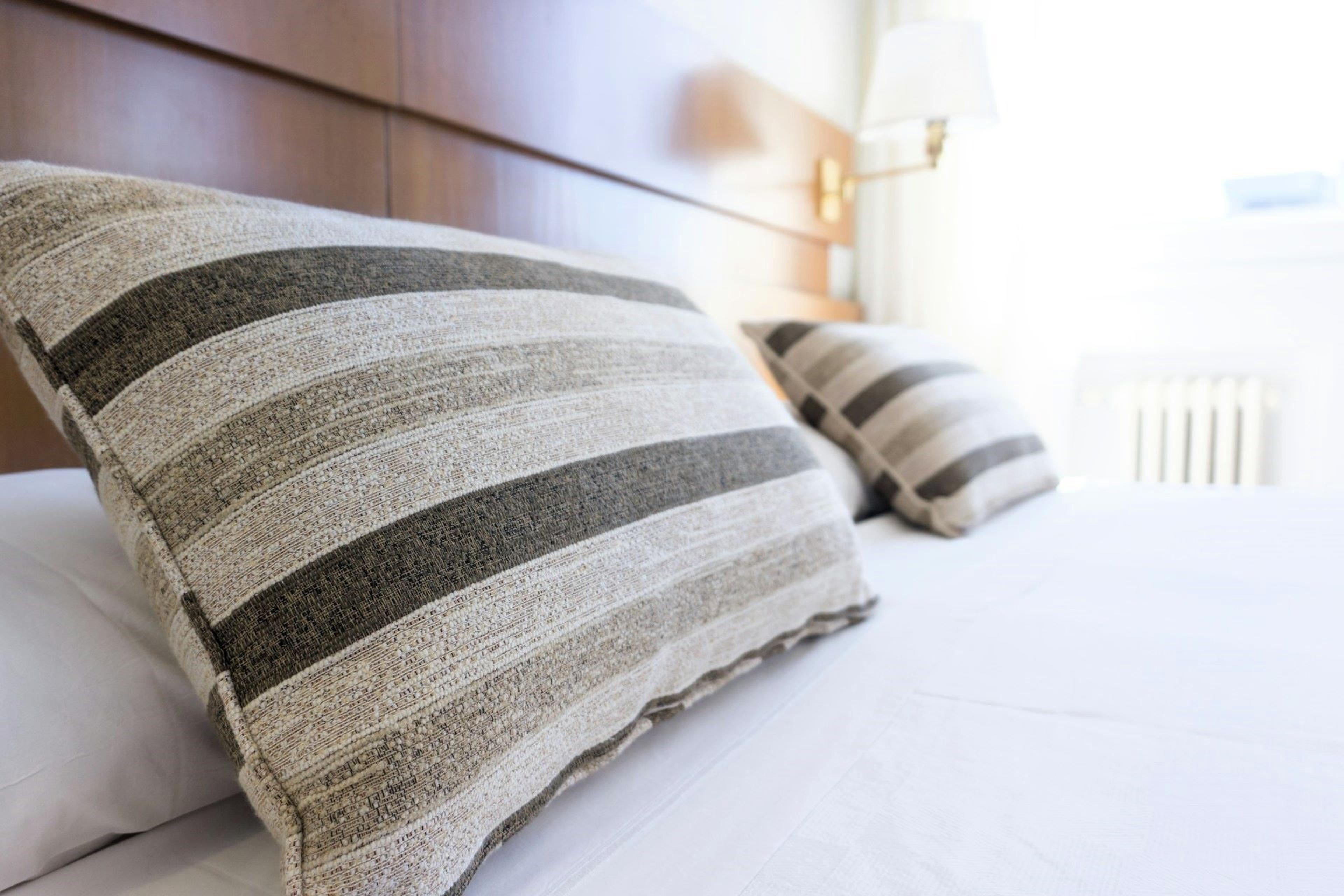 gray and black throw pillow on bed