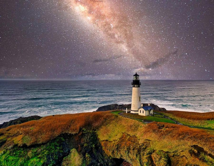A lighthouse beneath a starry sky in Newport, Oregon.