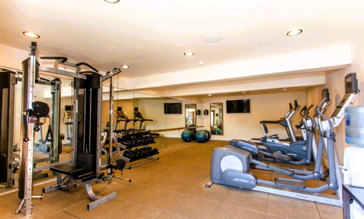 Photo of Casa Munras Garden Hotel & Spa - Fitness room with a Peloton bike, treadmill, elliptical, free weights, yoga mats, and Pilates balls