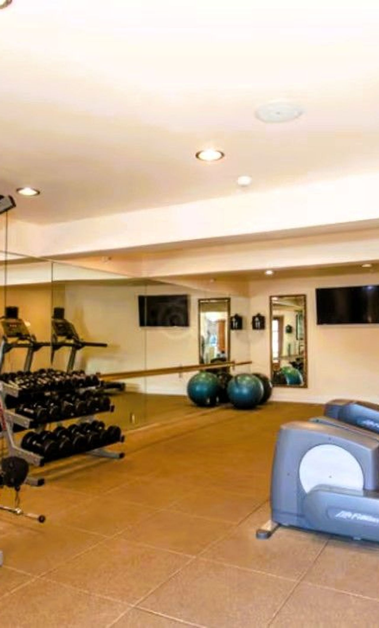 Photo of Casa Munras Garden Hotel & Spa - Fitness room with a Peloton bike, treadmill, elliptical, free weights, yoga mats, and Pilates balls